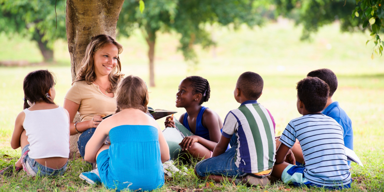 students reading outside in summer